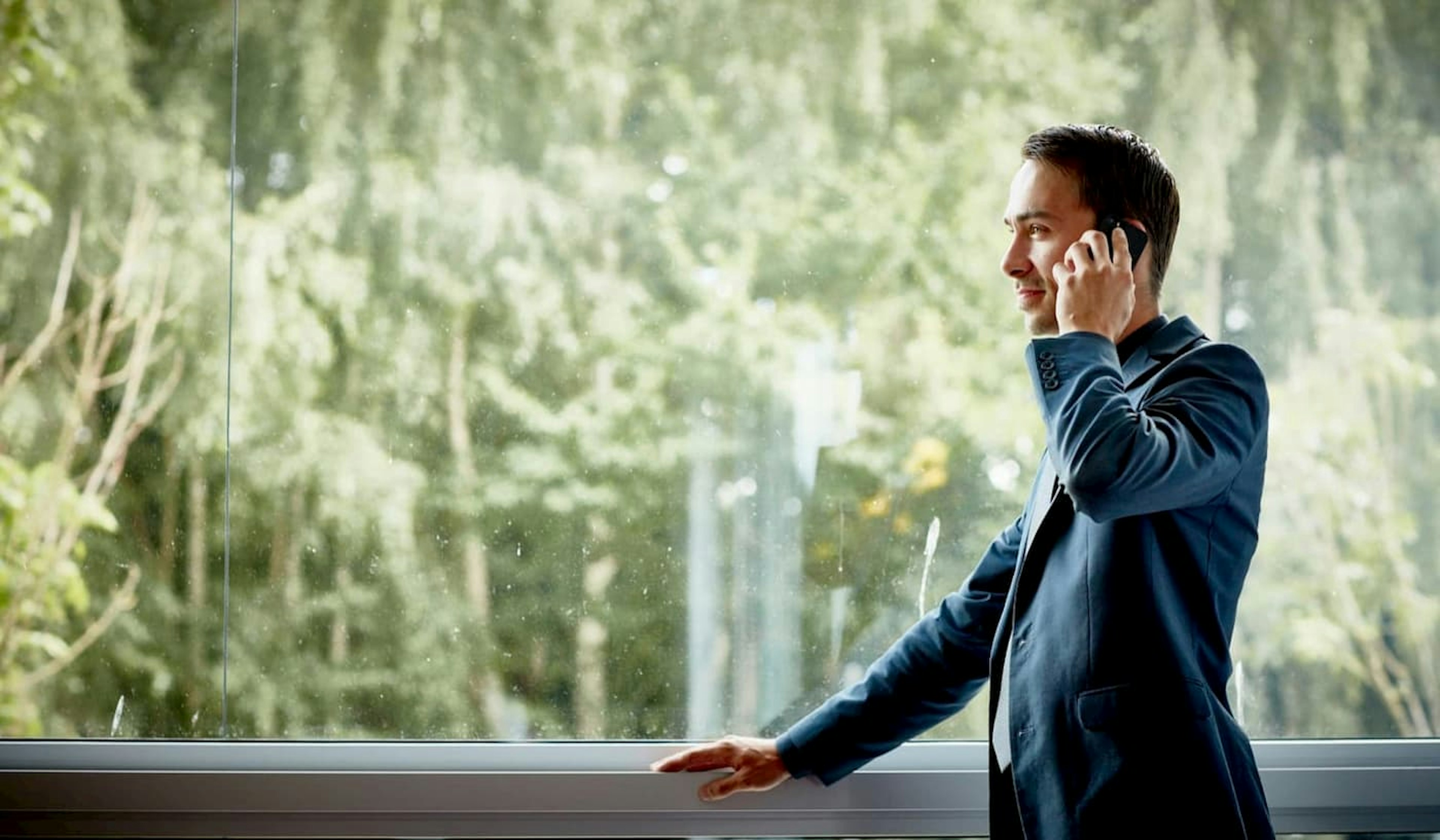 Projektleiter telefoniert am Fenster