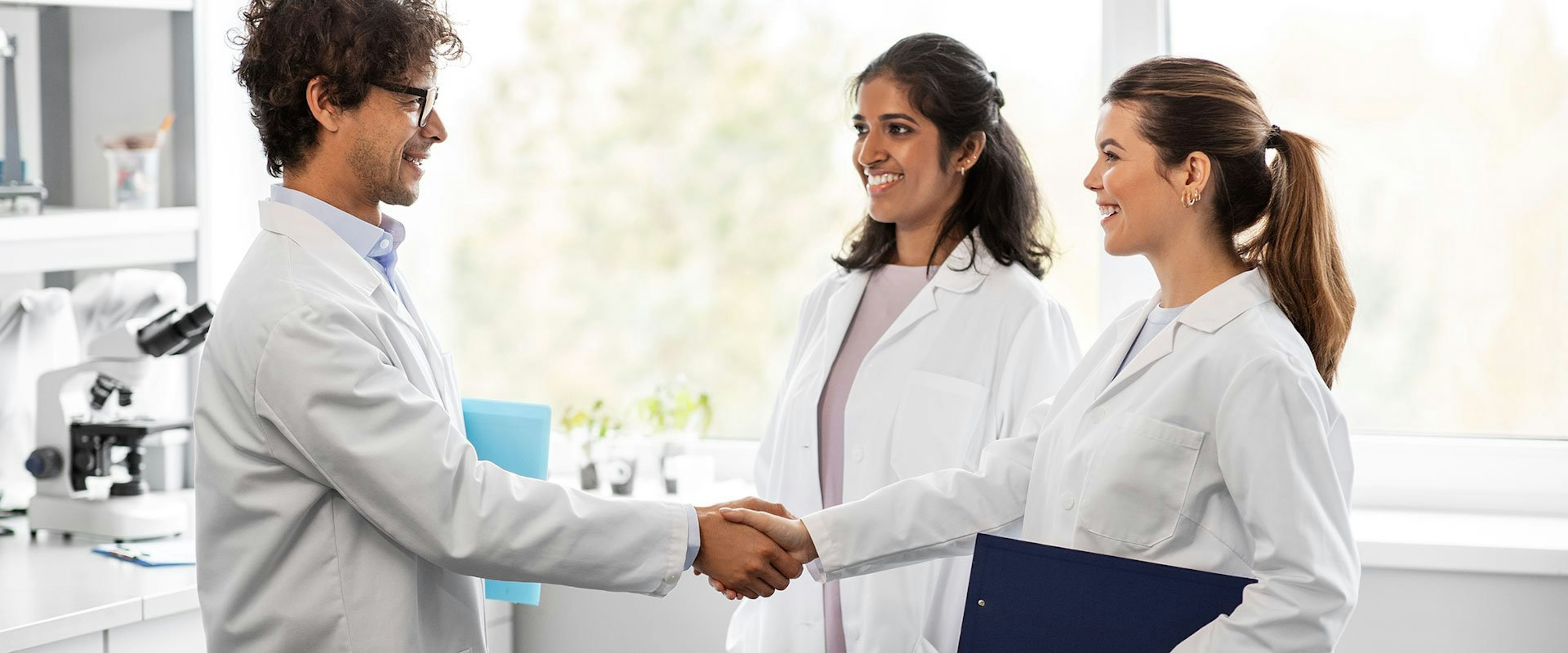 New employee in life science job shaking hands with team member