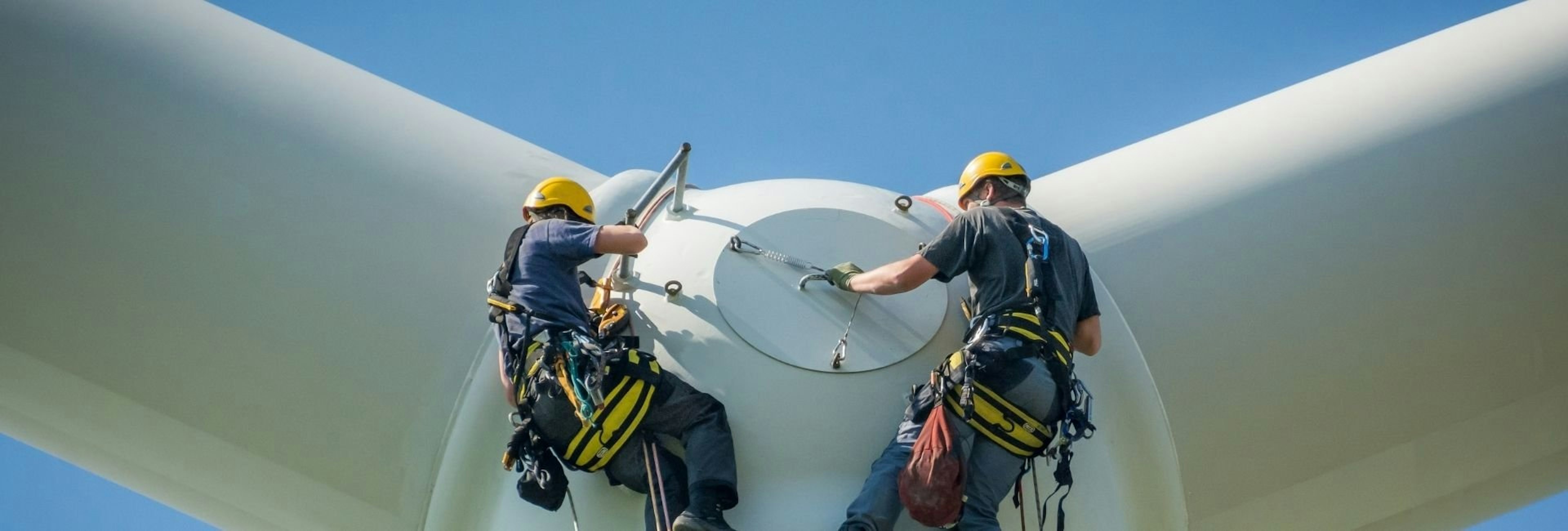 Two wind turbine technicians working on a turbine
