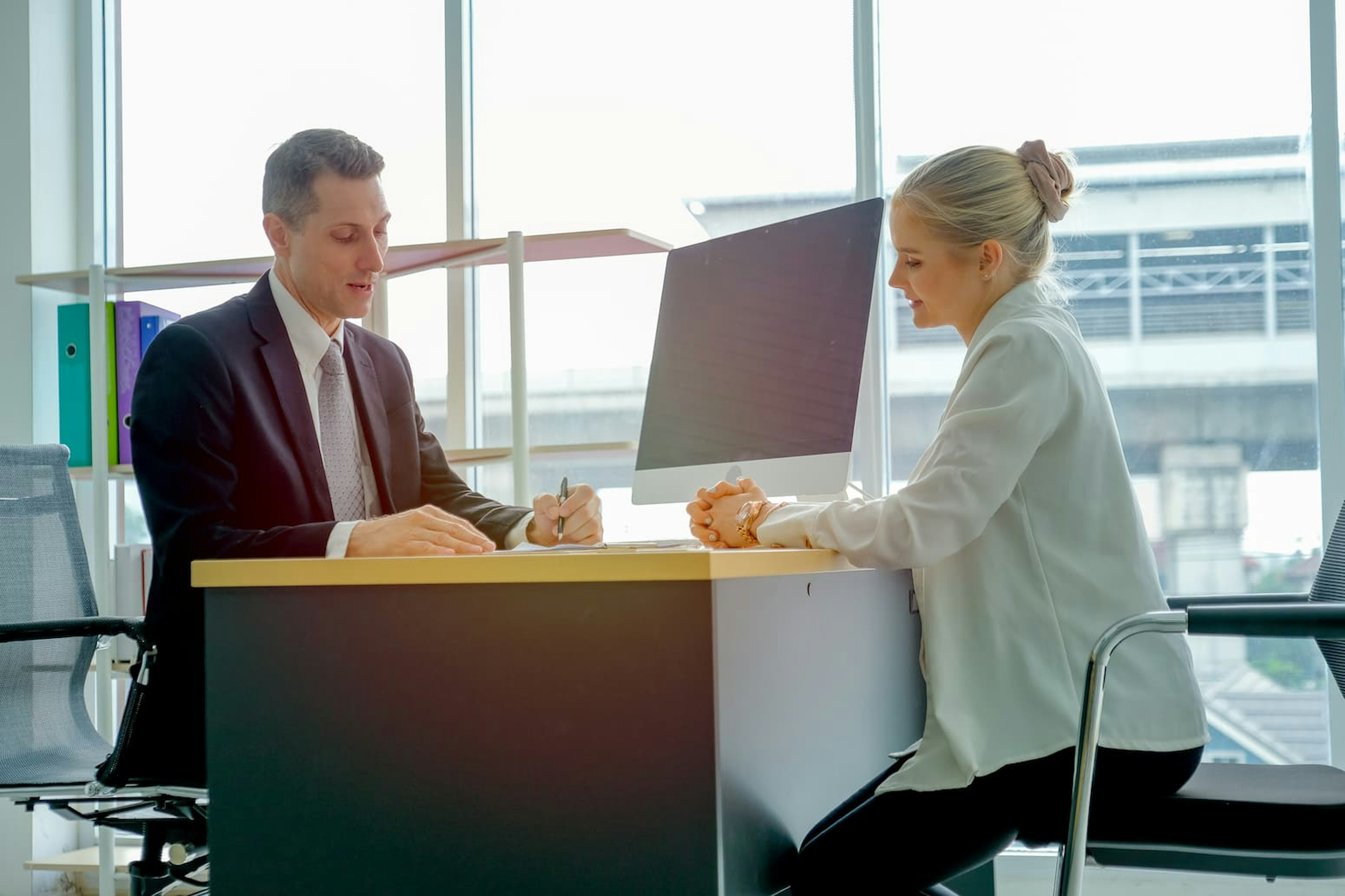 Man and woman sitting across each other at a desk