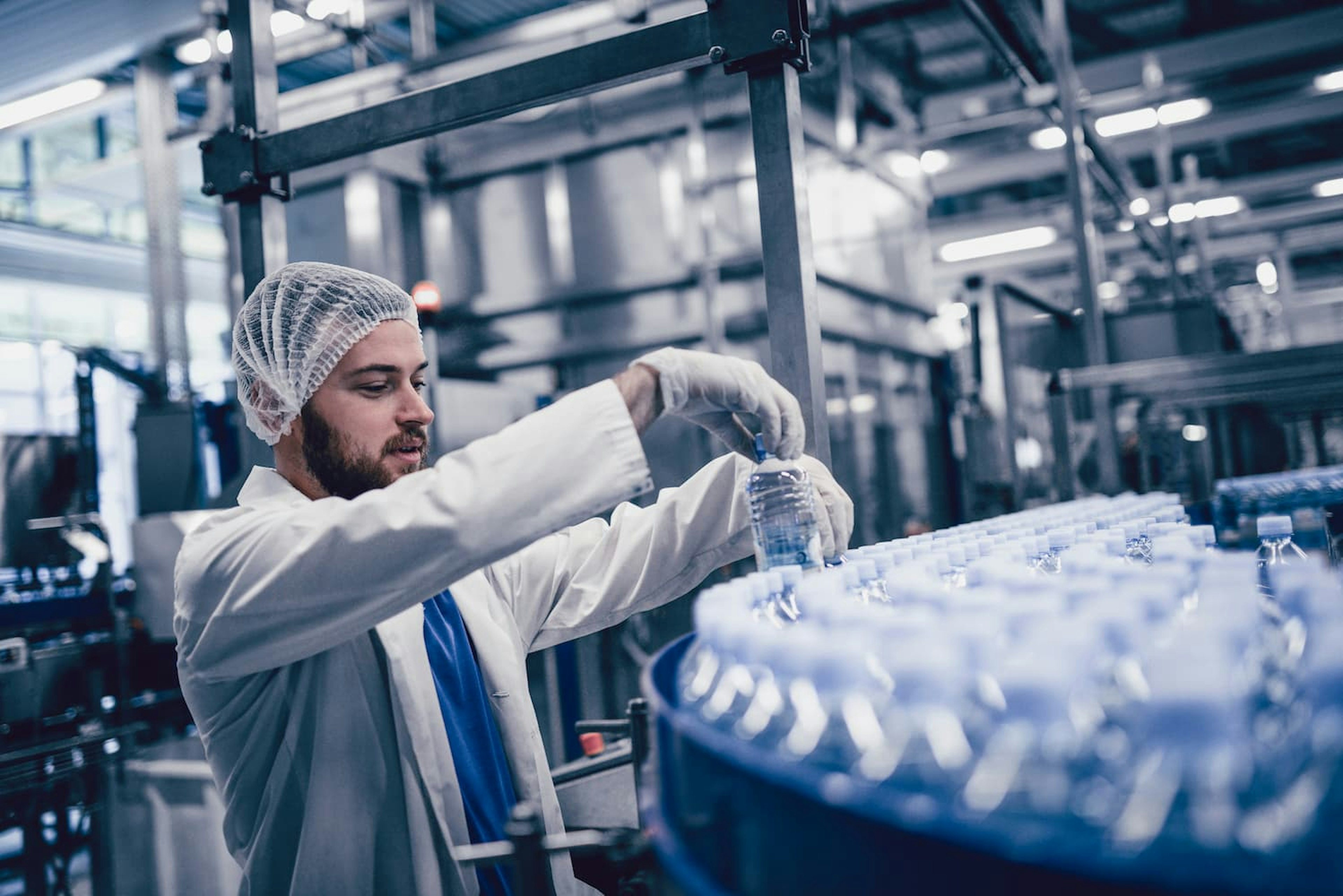 Man checking water bottles in factory