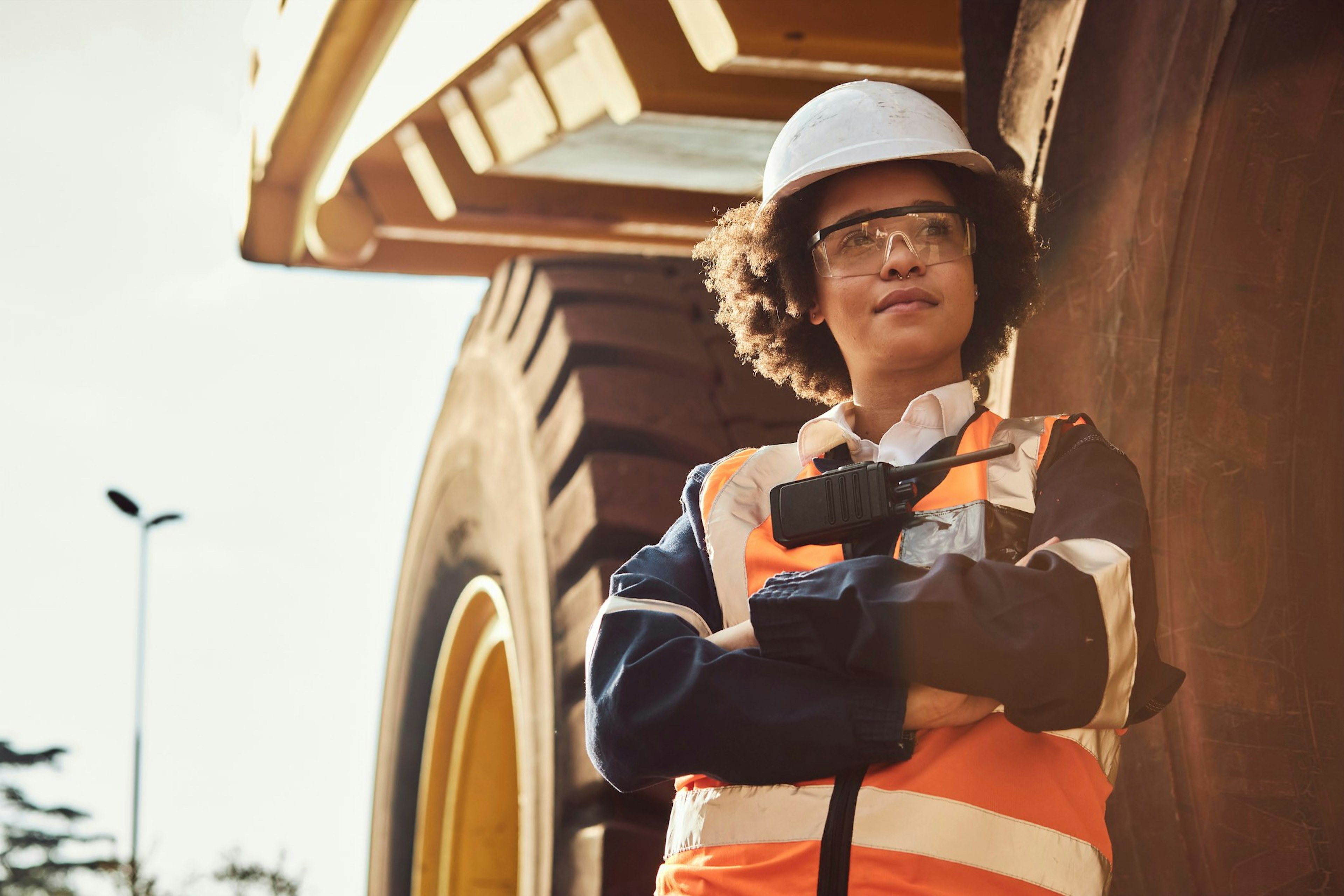 Woman in front of large mining machinery at work on a North American mining site.